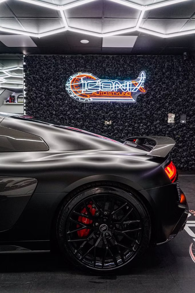 Rear wing and spoiler detail on a matte black sports car