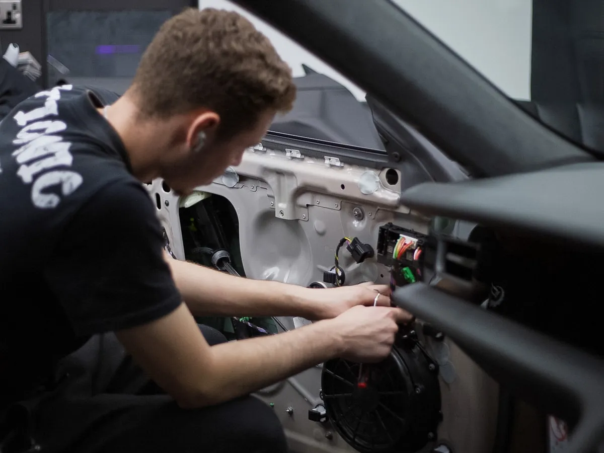 Iconix technician working on wiring behind a door panel