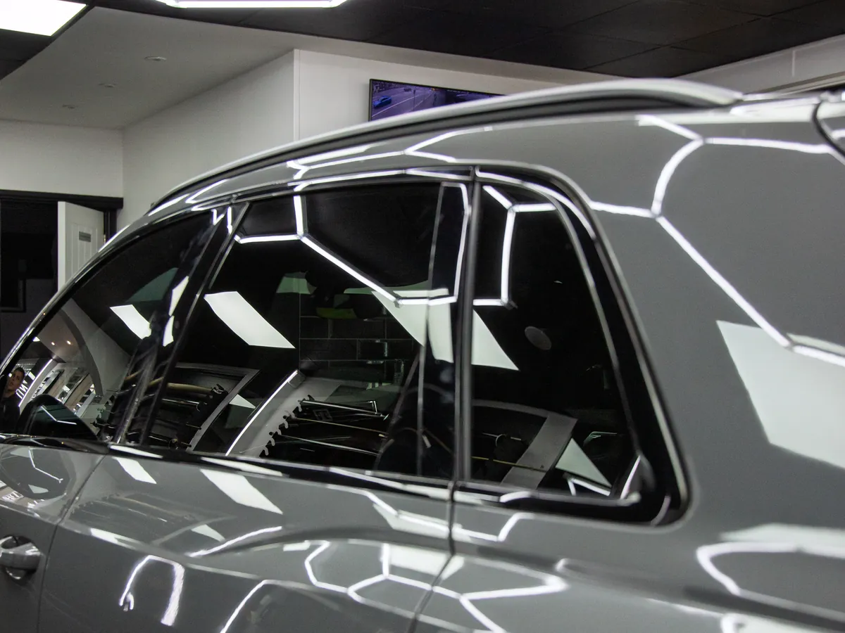 Crisp hex-light reflections in the paint of a grey Audi