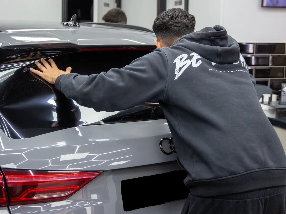 Iconix technician fitting tint film to the rear glass of an Audi RS Q3